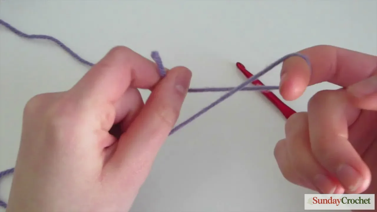 Crochet slipknot step using purple yarn and a crochet hook