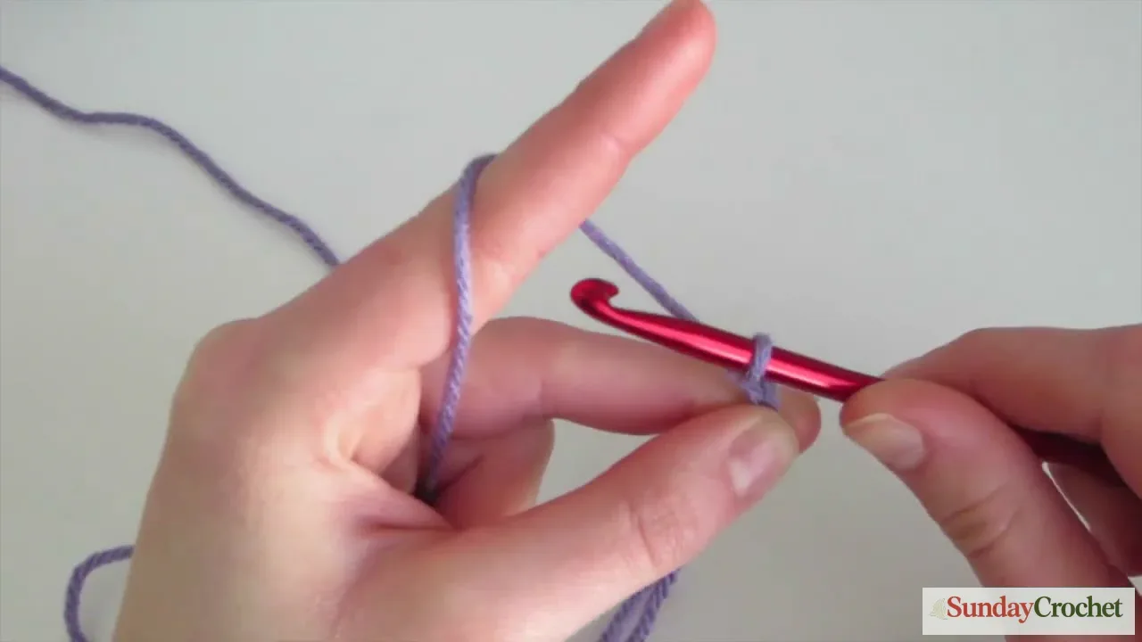 Crochet chain stitch made by pulling purple yarn through a loop