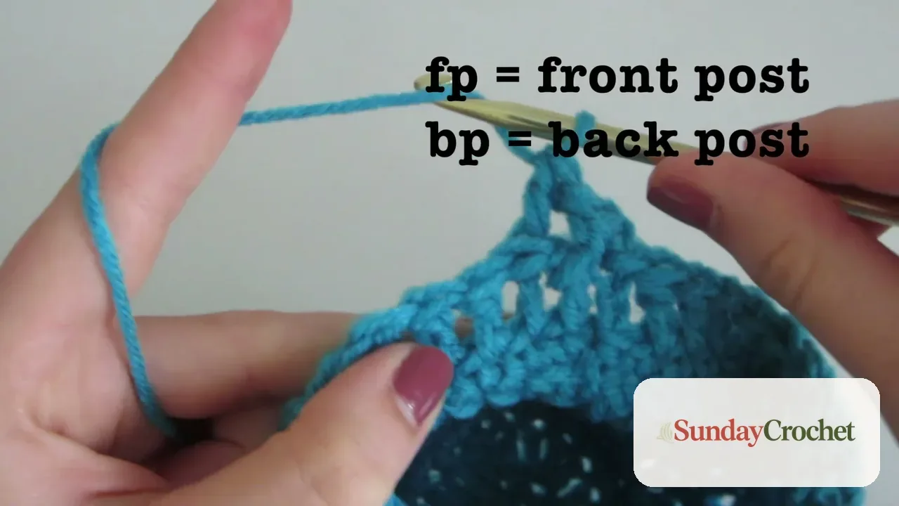 Close-up of blue crochet fabric and hook demonstrating placement for front and back post stitches