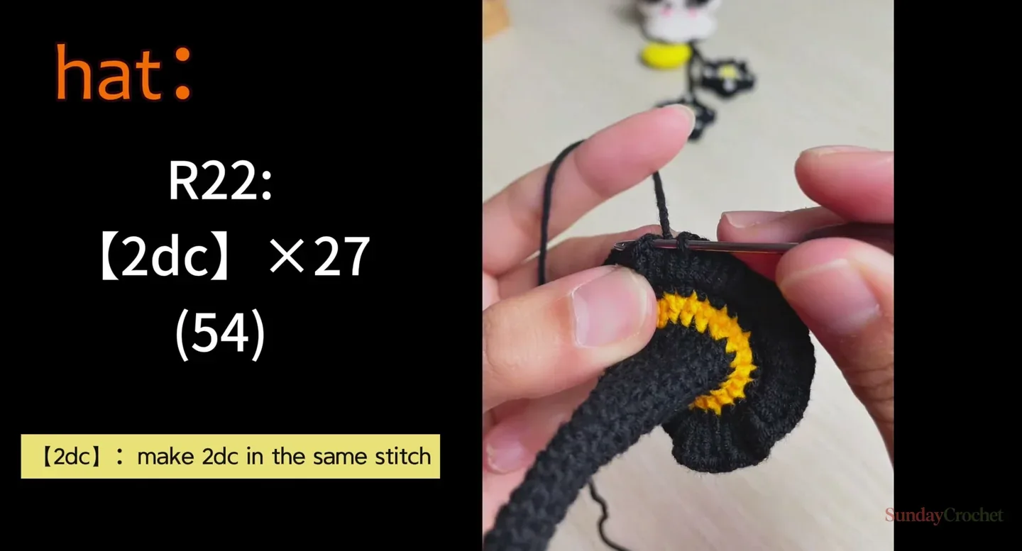 Hands crochet the black brim of a witch hat after a yellow band, following the double-crochet increase round