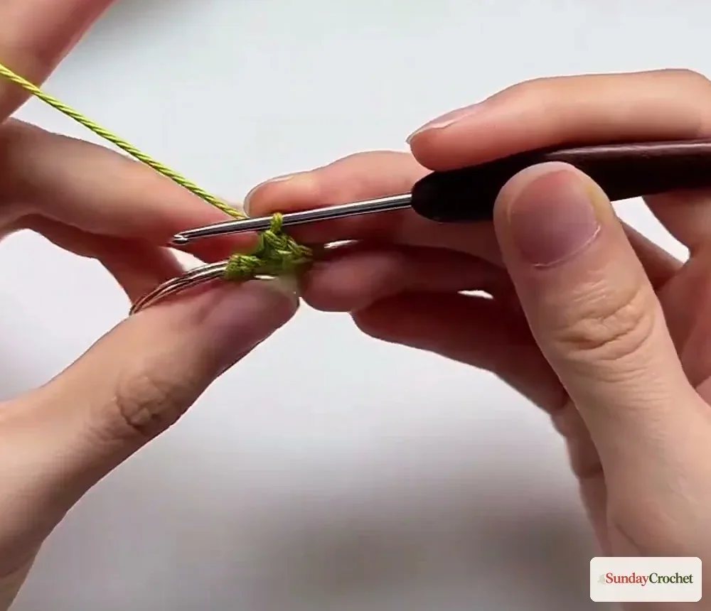 Hands work a slip stitch at a row edge before crocheting the middle stitches of the mini bag