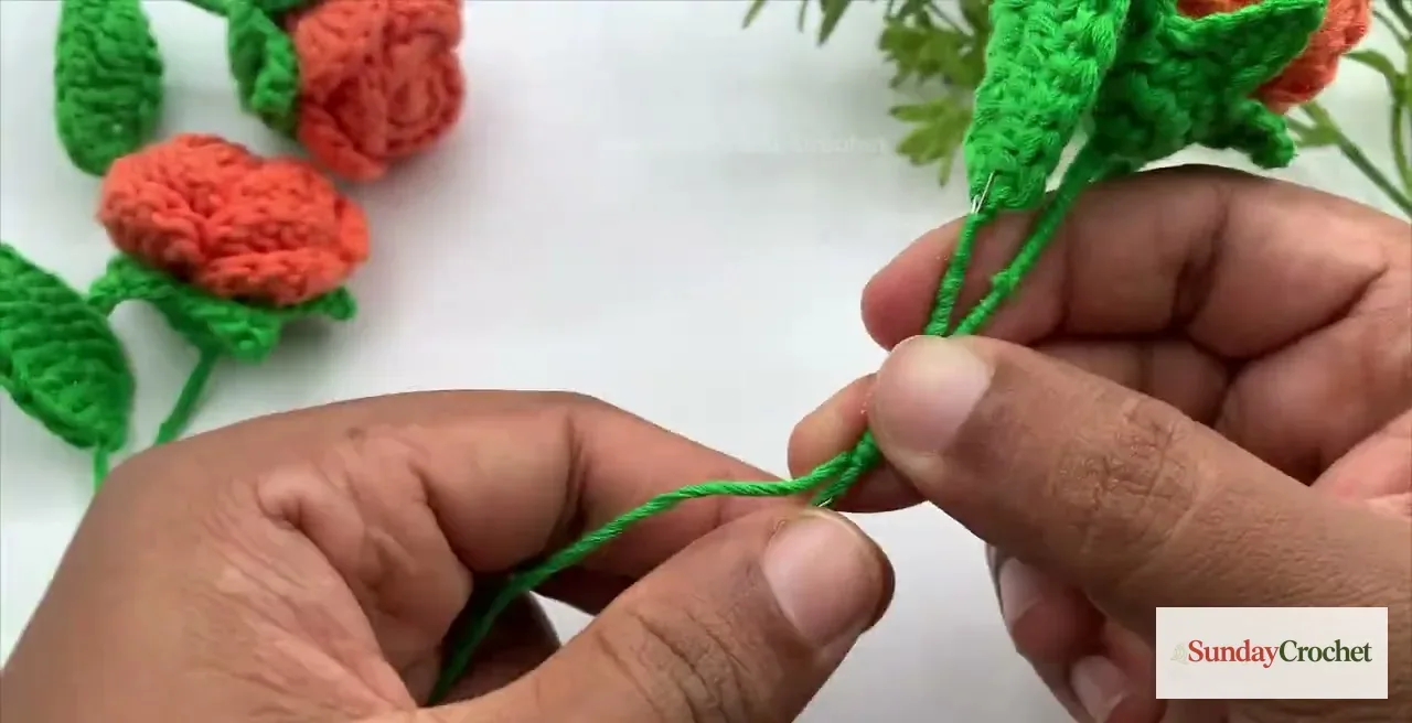 Green yarn is glued and wrapped around the wire core to cover the rose stem