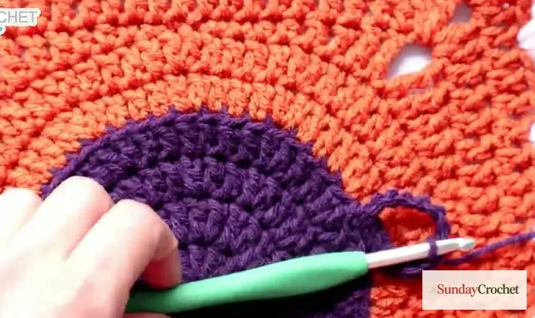 A purple loop handle is anchored to the orange square beside the round cauldron