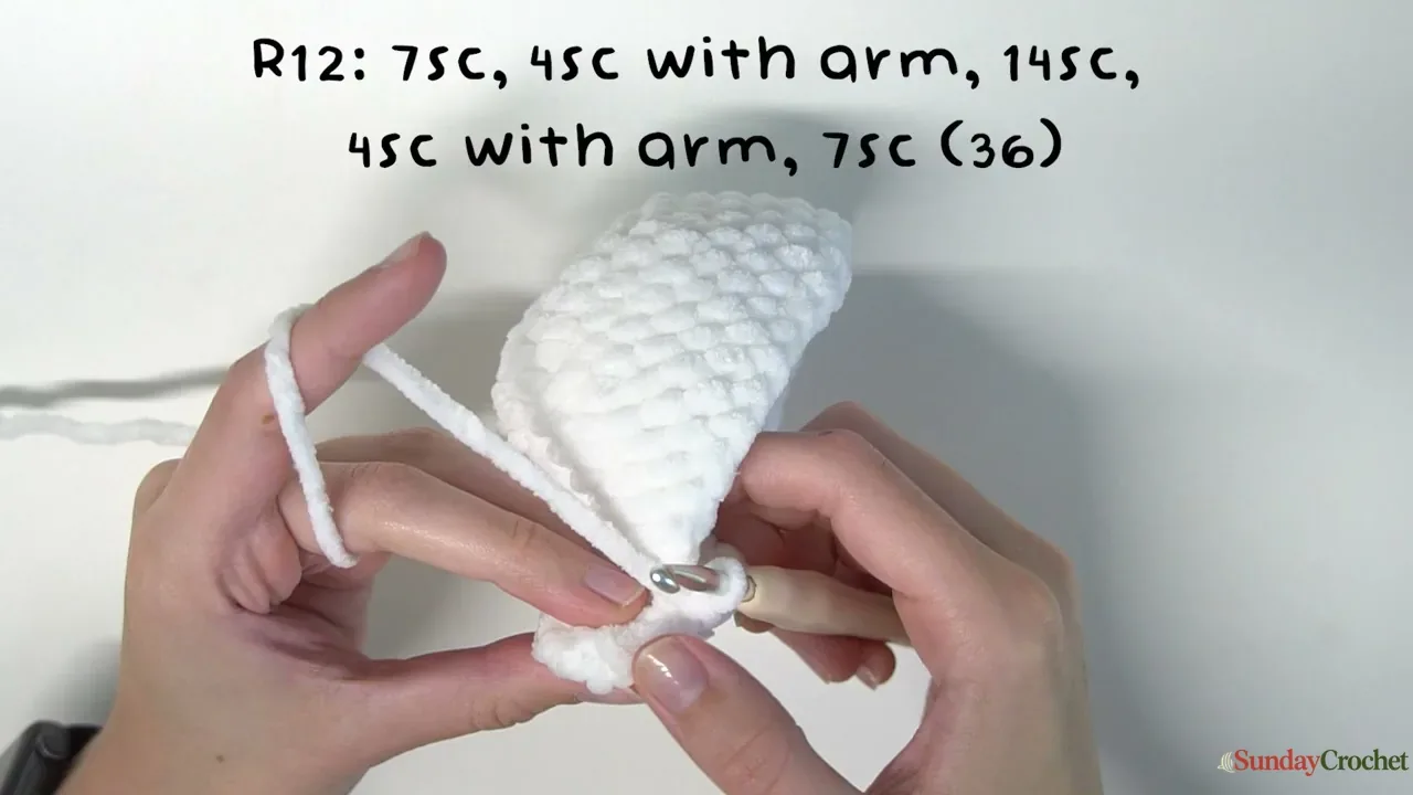 Hands crochet a folded white ghost arm into the body round without sewing it on separately