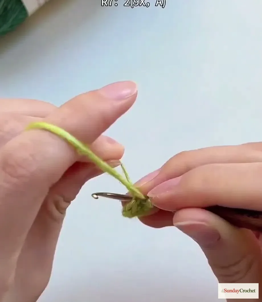 Hands crochet the small single-crochet base of the Christmas tree from a magic ring