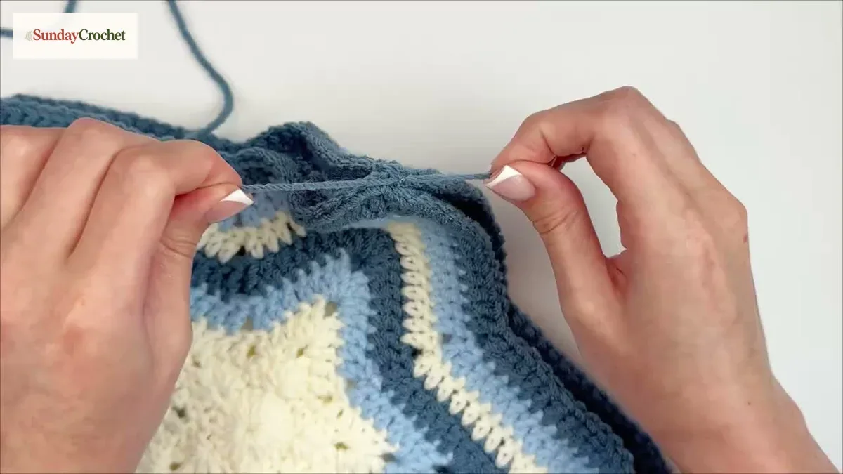 A tapestry needle sews aligned back loops along the edge of the two star bag panels