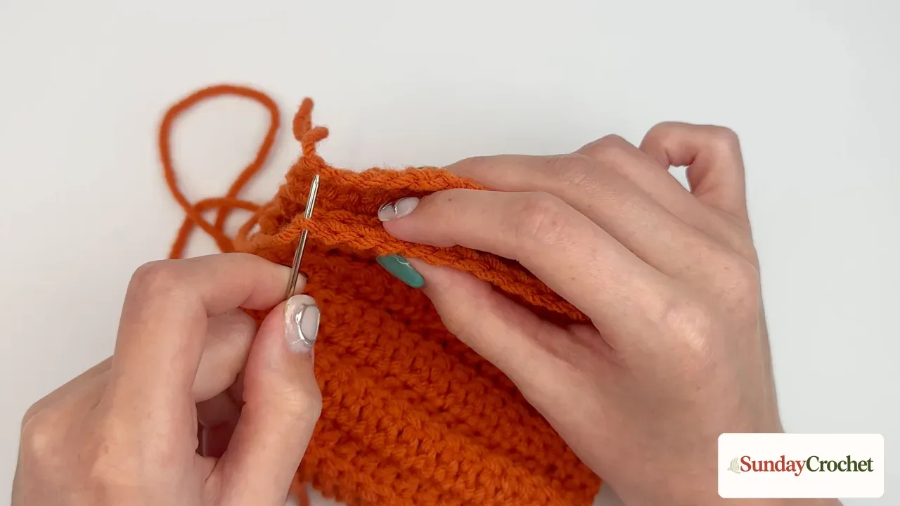 A tapestry needle joins the first and last rows of the ribbed pumpkin panel