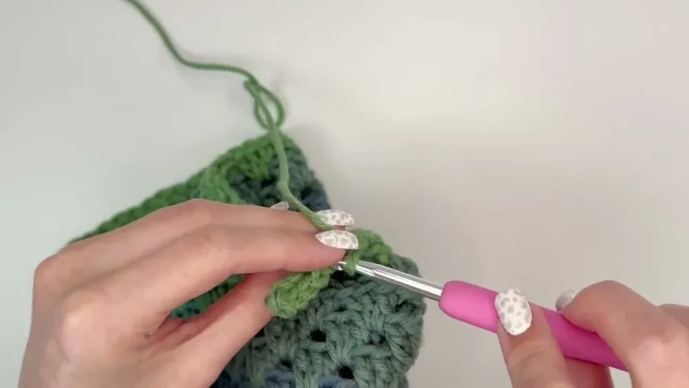 A hook works back-loop slip stitches to build the ribbed cuff along a crochet sleeve