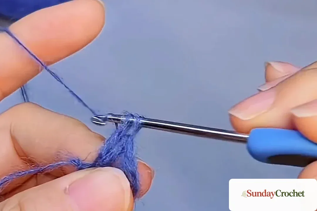Close view of the blue five-double-crochet starting base on the hook
