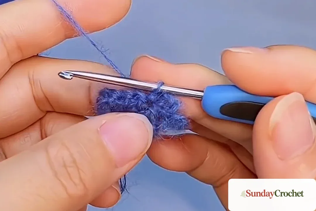 Blue crochet fan edge with the hook beginning a chain-three scallop