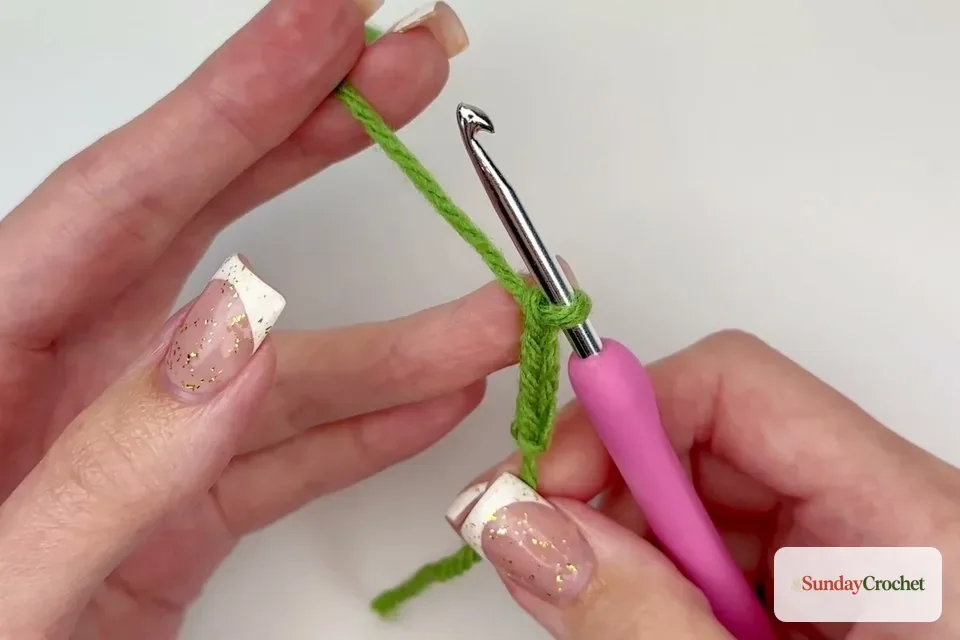 Green foundation chain for the leaf with the crochet hook in the working loop