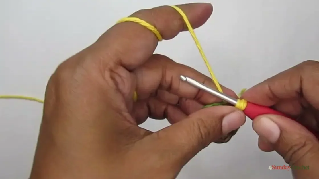Golden yarn is joined to the paired brown and green sunflower-center circles to begin a petal.