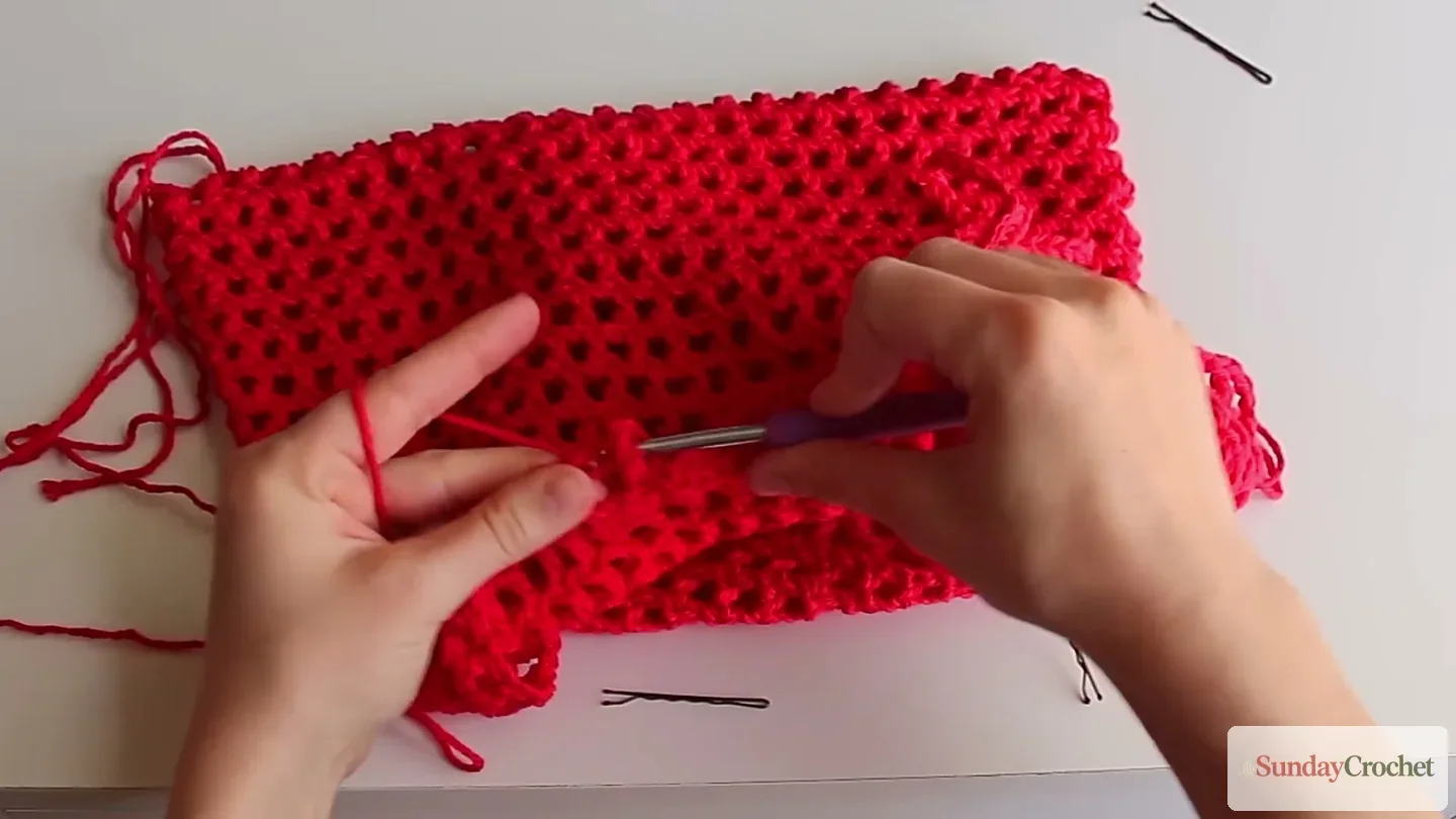 The crocheted strap is worked into the mesh bag opening at a marked section