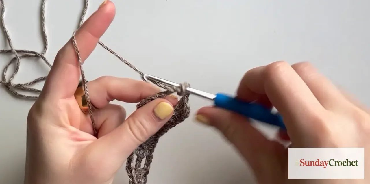 A double-crochet cluster is worked across treble posts and chain spaces