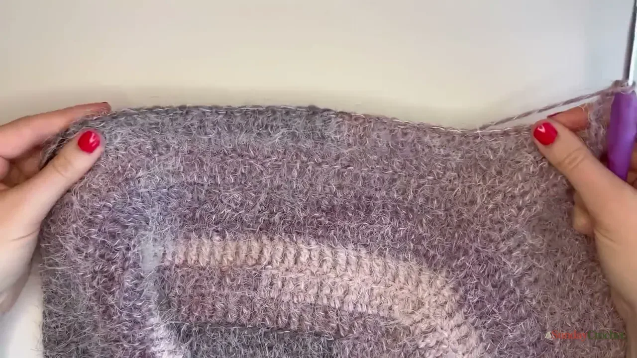 The fuzzy crochet raglan yoke lies flat for a fit check before the sleeves are separated