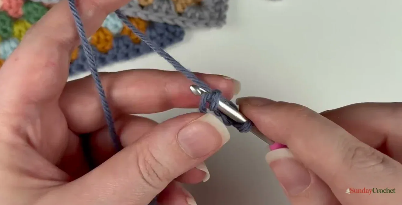 Hands form the small chain ring used to begin a granny square