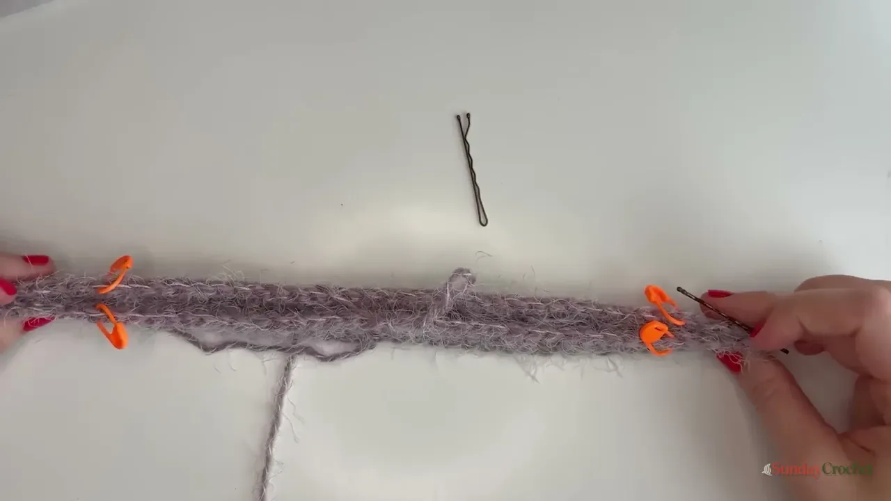 Orange stitch markers show four evenly spaced raglan increase points along the crochet yoke
