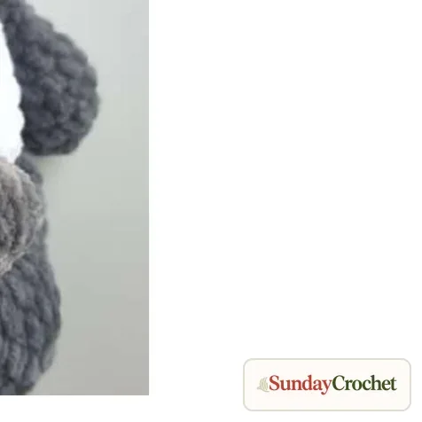 Small dark crocheted tail positioned on the lower back of the panda body